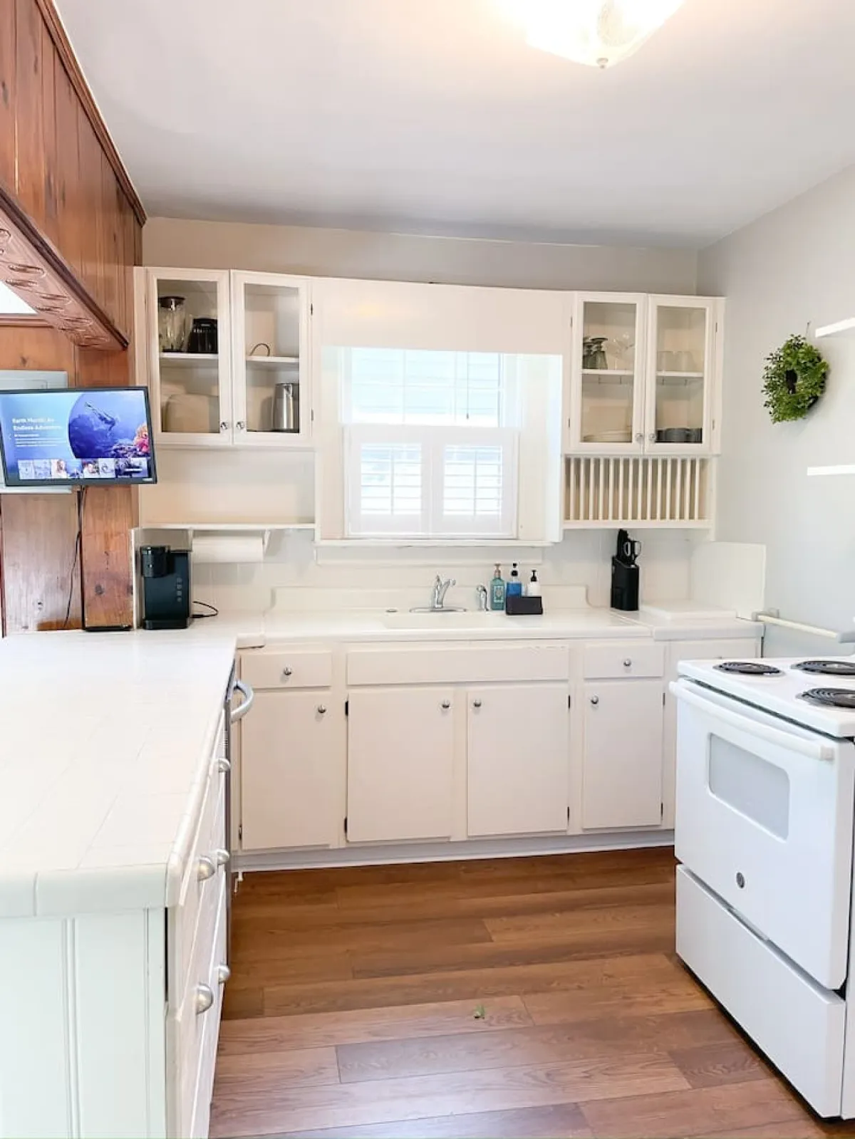 This image centers on the kitchen countertop, sink, stove, and surrounding cabinets. It offers a clear view of the kitchen’s workspace, emphasizing the practical amenities available for meal preparation. The setup is neat and functional, evoking a homey vibe that would appeal to those looking for a space to cook comfortably.