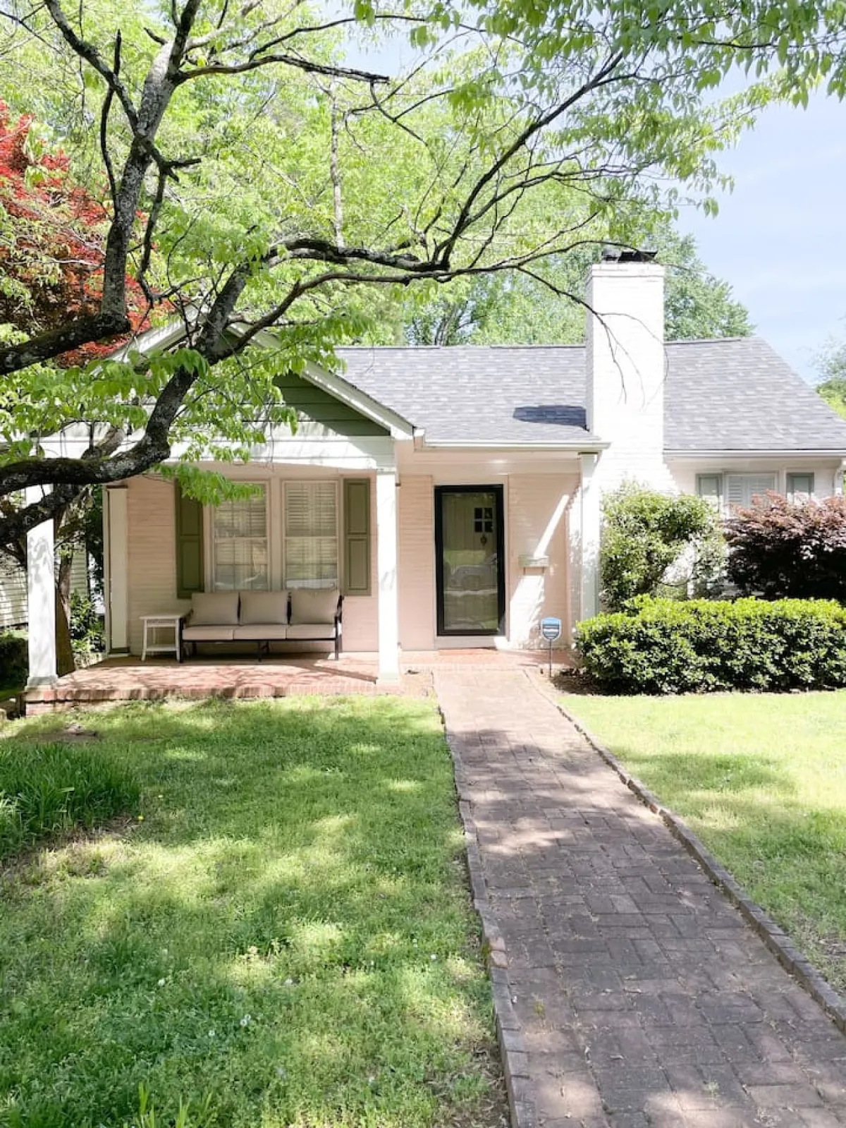 A charming front porch framed by greenery and a welcoming pathway, offering an inviting spot to enjoy morning coffee or evening chats. The scene connects the home to the vibrant neighborhood atmosphere described in the section.